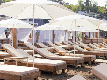 Пара шезлонгов под зонтом целый день